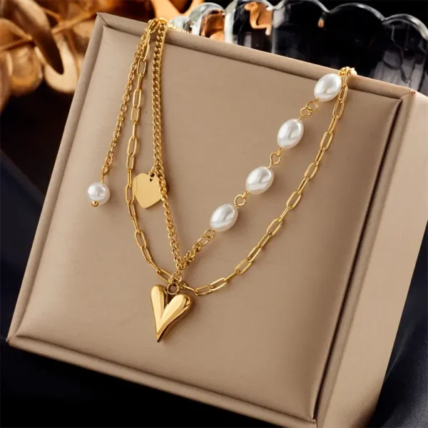 8967228a-b2a3-4692-aa64-8f8eed5c5243 Collier à Chaîne Multicouches avec Pendentif Cœur Doré & Perles Blanches
