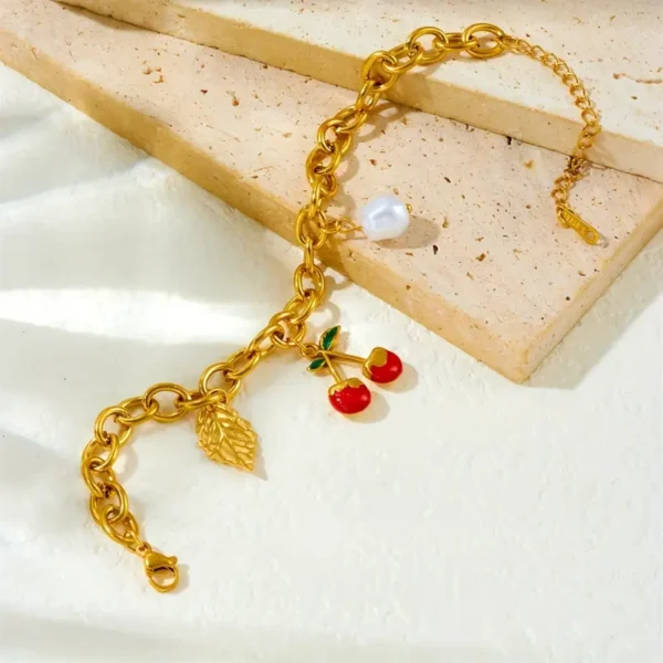 aca01372-584b-43d2-b27d-4bfe91e883ef Bracelet en acier inoxydable doré élégant avec pendentif cerise et feuille rouge