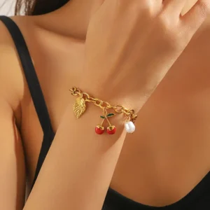 Bracelet en acier inoxydable doré élégant avec pendentif cerise et feuille rouge