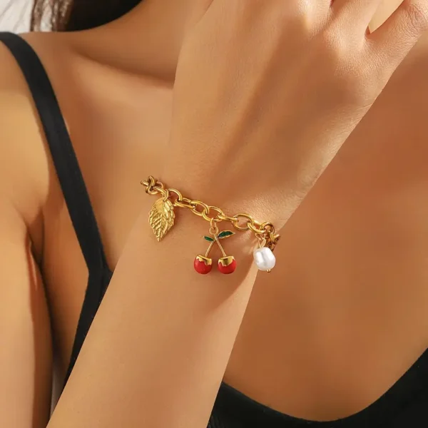 decbdf9a-4030-4e1c-9443-9b2c7fdba59a Bracelet en acier inoxydable doré élégant avec pendentif cerise et feuille rouge