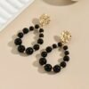 Capture d’écran 2025-09-17 115442 Boucles d'oreilles en perles noires tombantes avec accents dorés