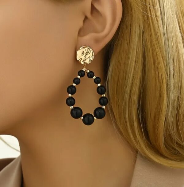 Capture d’écran 2025-09-17 115508 Boucles d'oreilles en perles noires tombantes avec accents dorés