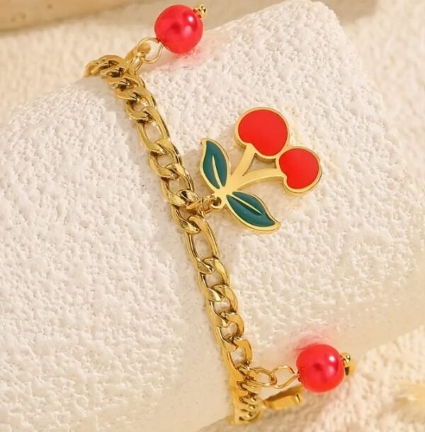 Bracelet doré à pendentif cerise et perles rouges