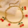 Bracelet doré à pendentif cerise et perles rouges